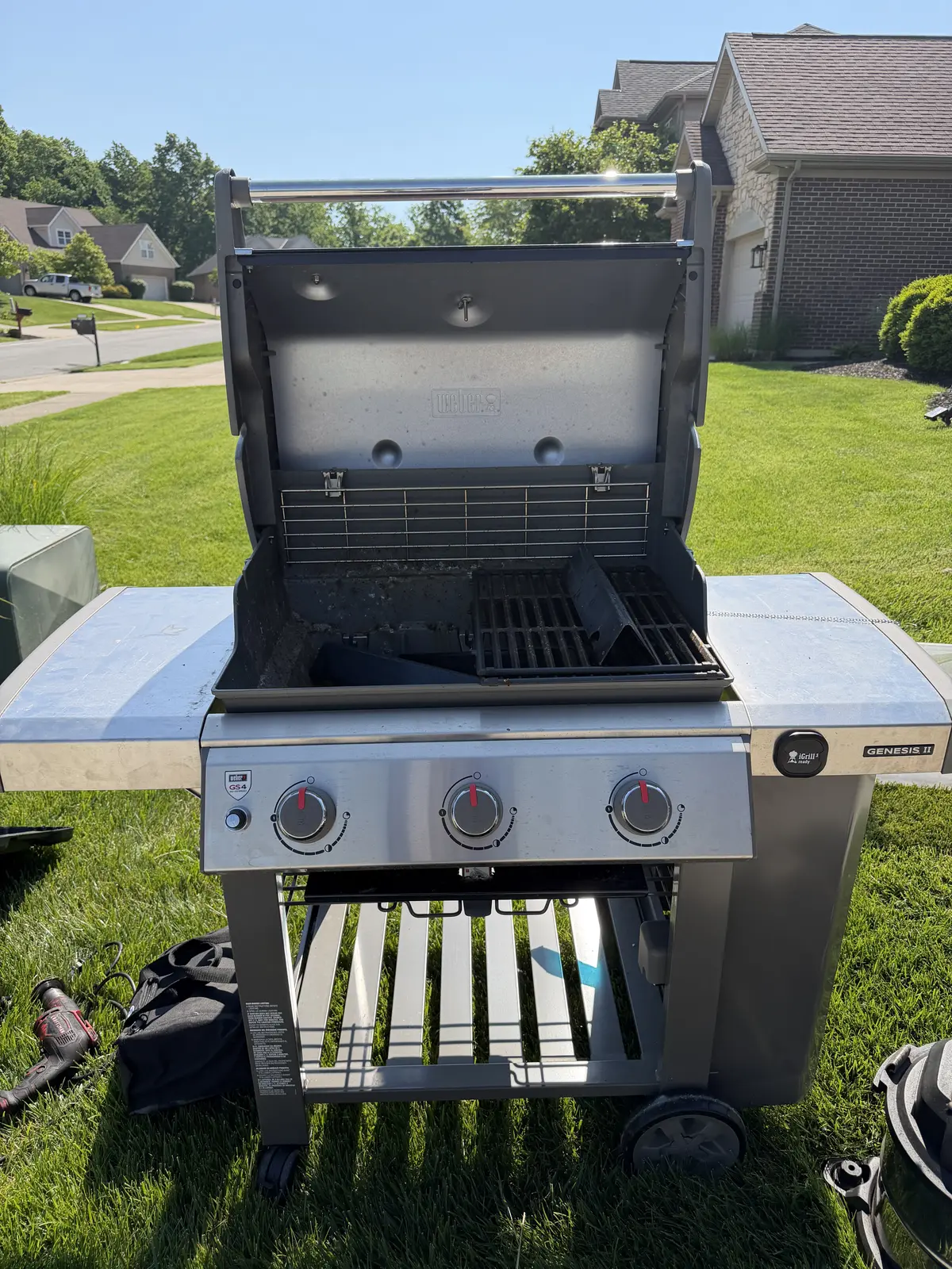 Before: a Weber Genesis II 3-burner gas grill mid-service — grates removed, heat shields and burner area exposed with carbonized buildup